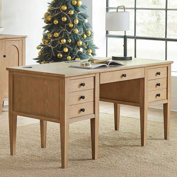 Light wood desk with Christmas tree behind it