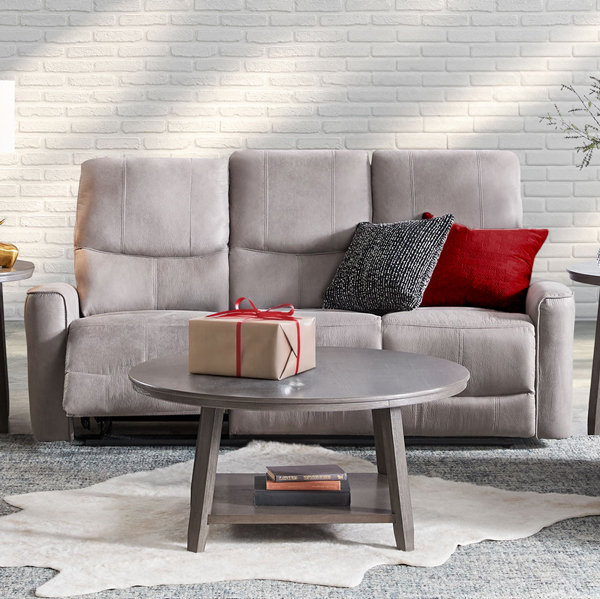 Beige reclining sofa in a room with a gift on the table