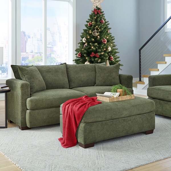 Green contemporary sofa with a Christmas tree and red throw blanket