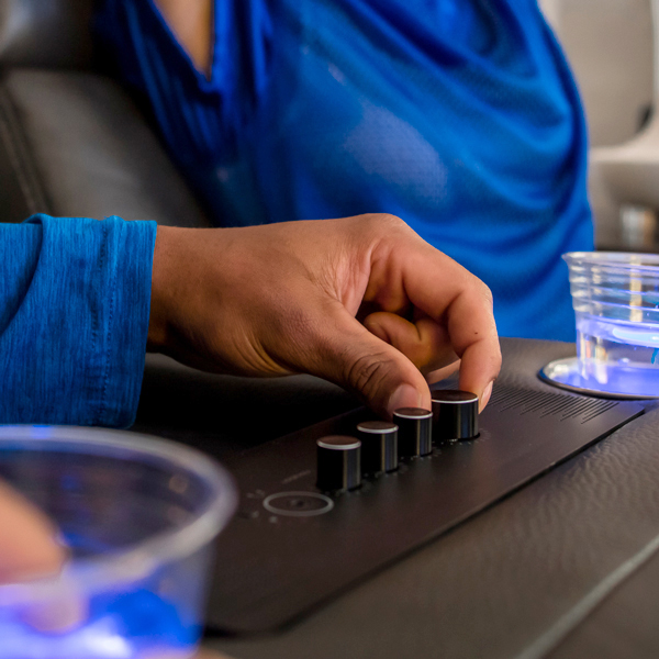 Hand adjusting audio controls on a sofa